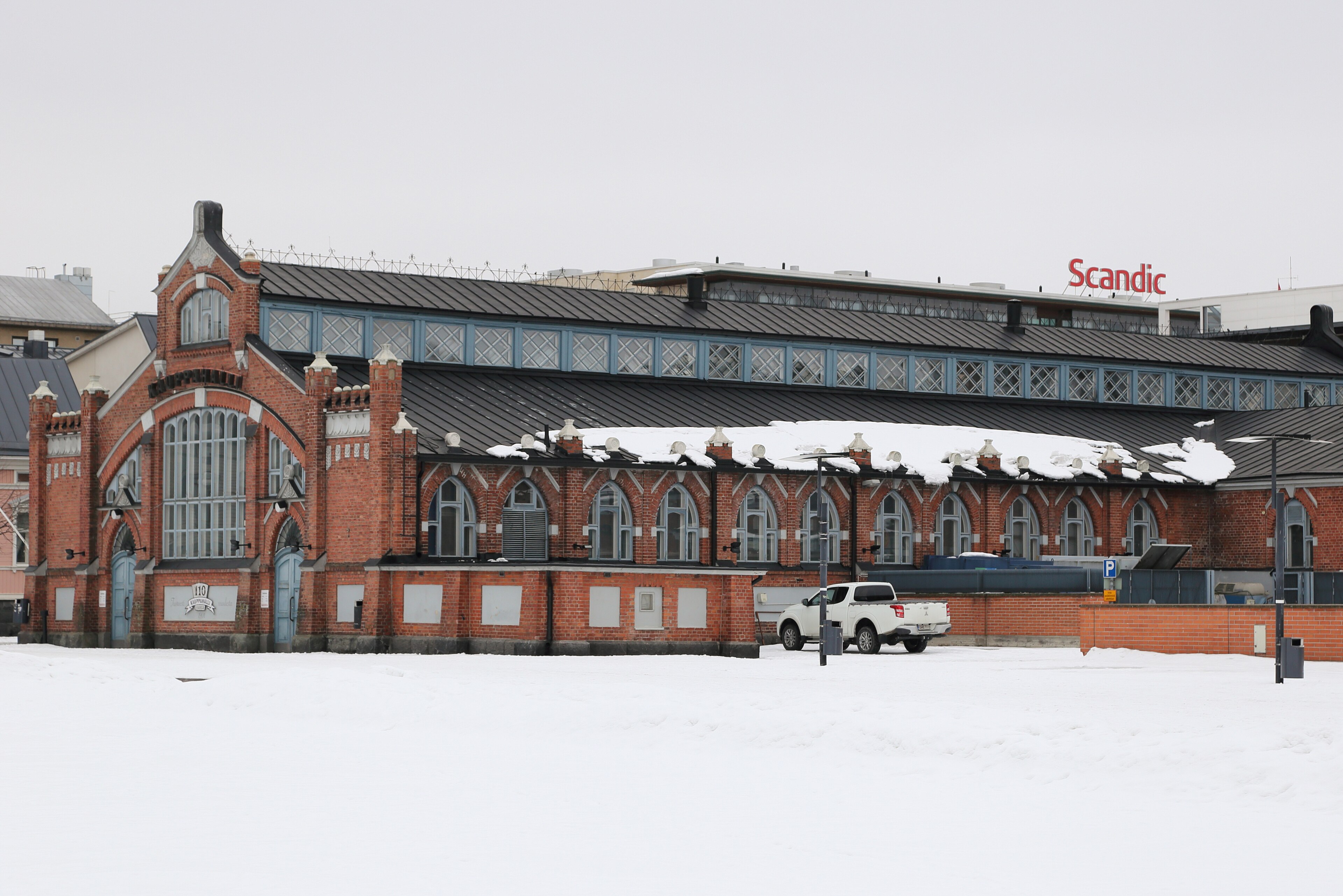 Oulu Market Hall’s arched brick gable and long facade overlooking the snow-covered market square