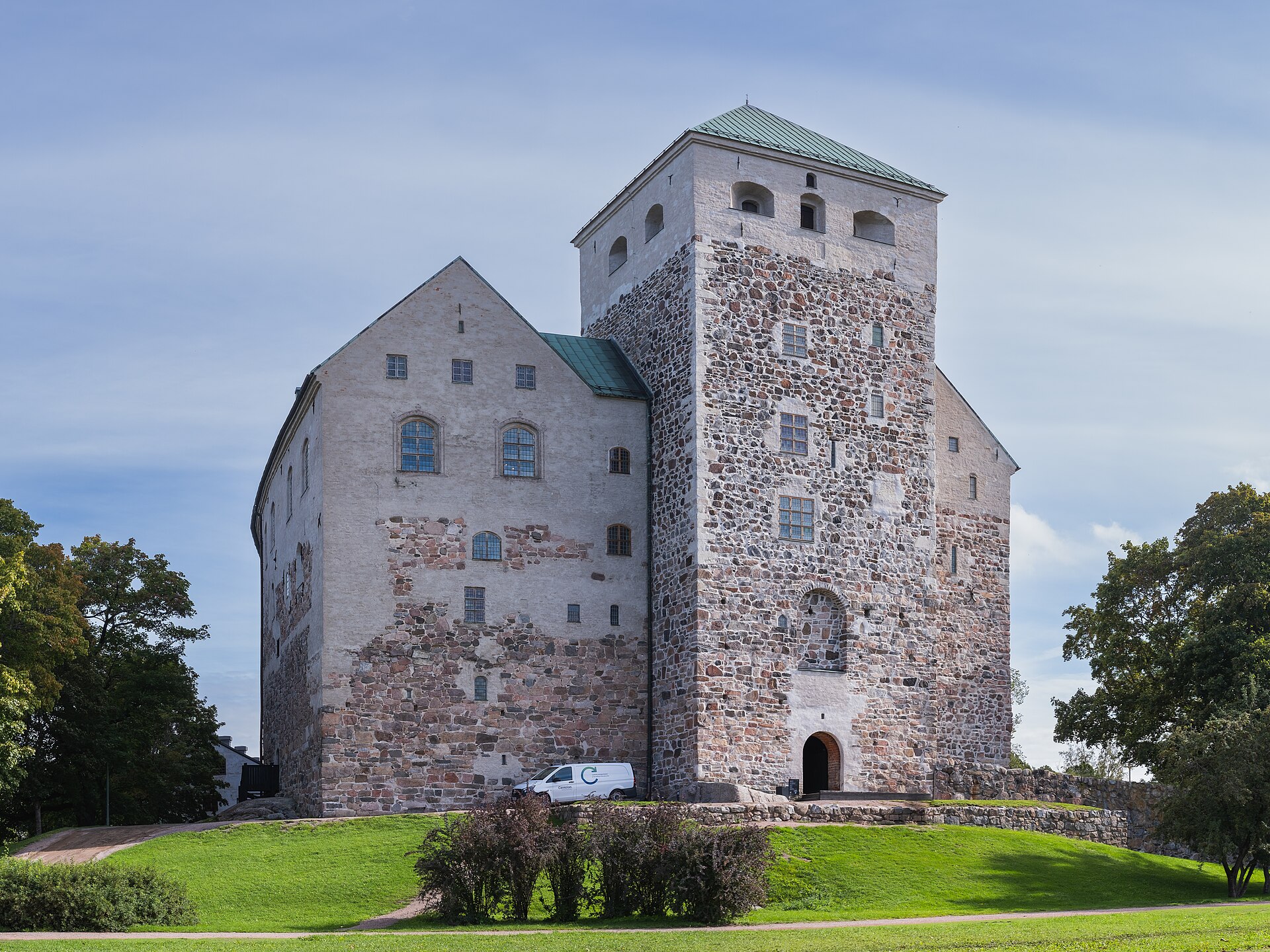 The stone towers and green roofs of Turku Castle above its lawns