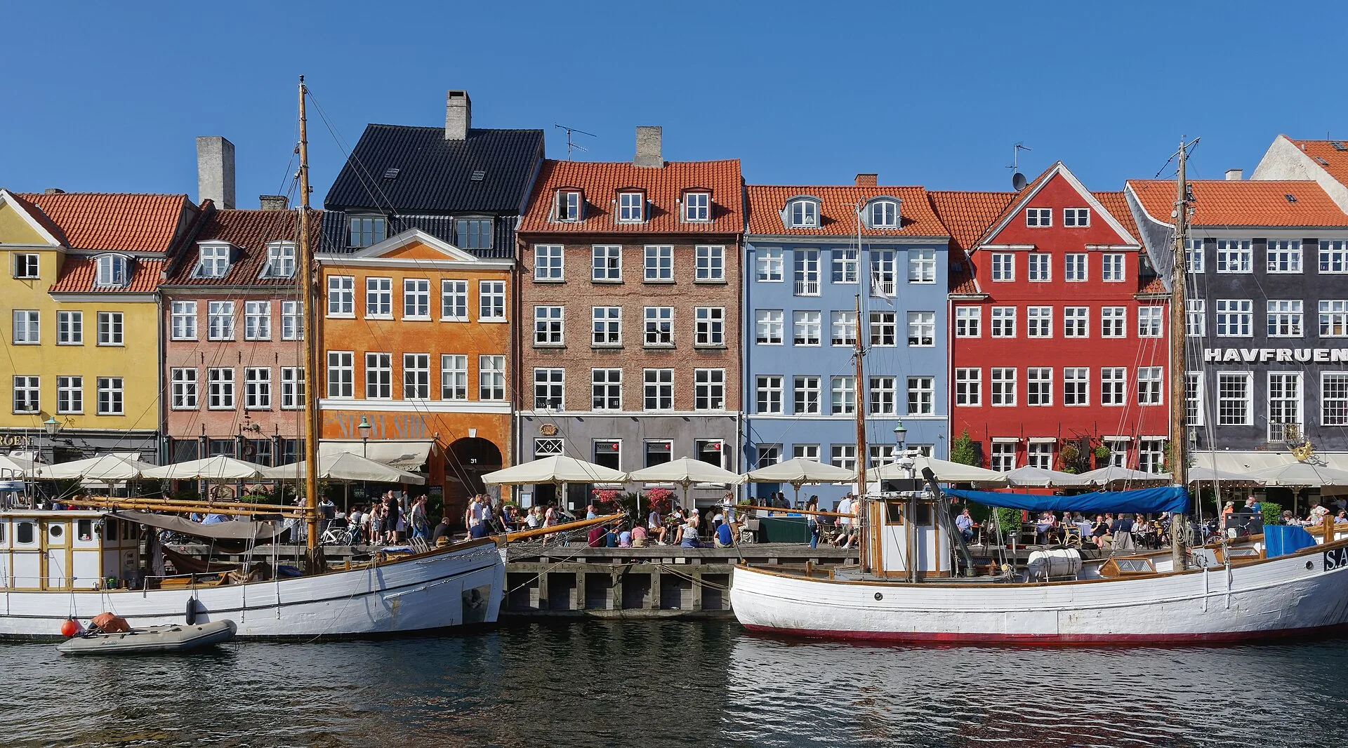 Colourful historic waterfront houses and moored boats along Nyhavn in Copenhagen, Denmark