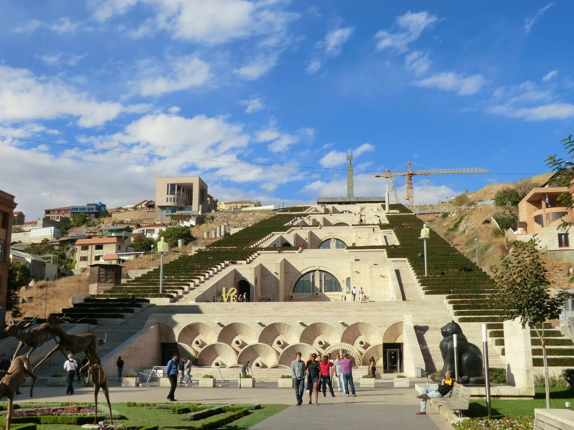 The stepped terraces, pale stone arches and gardens of Yerevan’s Cascade with visitors in the foreground