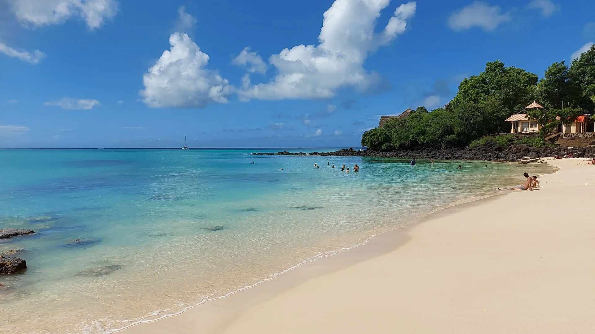 The curved sand and turquoise water of La Cuvette beach in Grand Baie