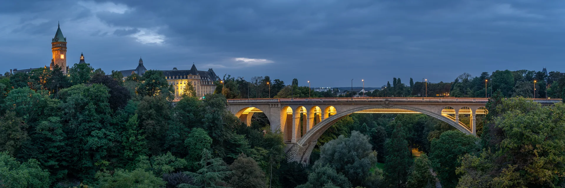 Adolphe Bridge above the Pétrusse valley, with Luxembourg City illuminated at dusk