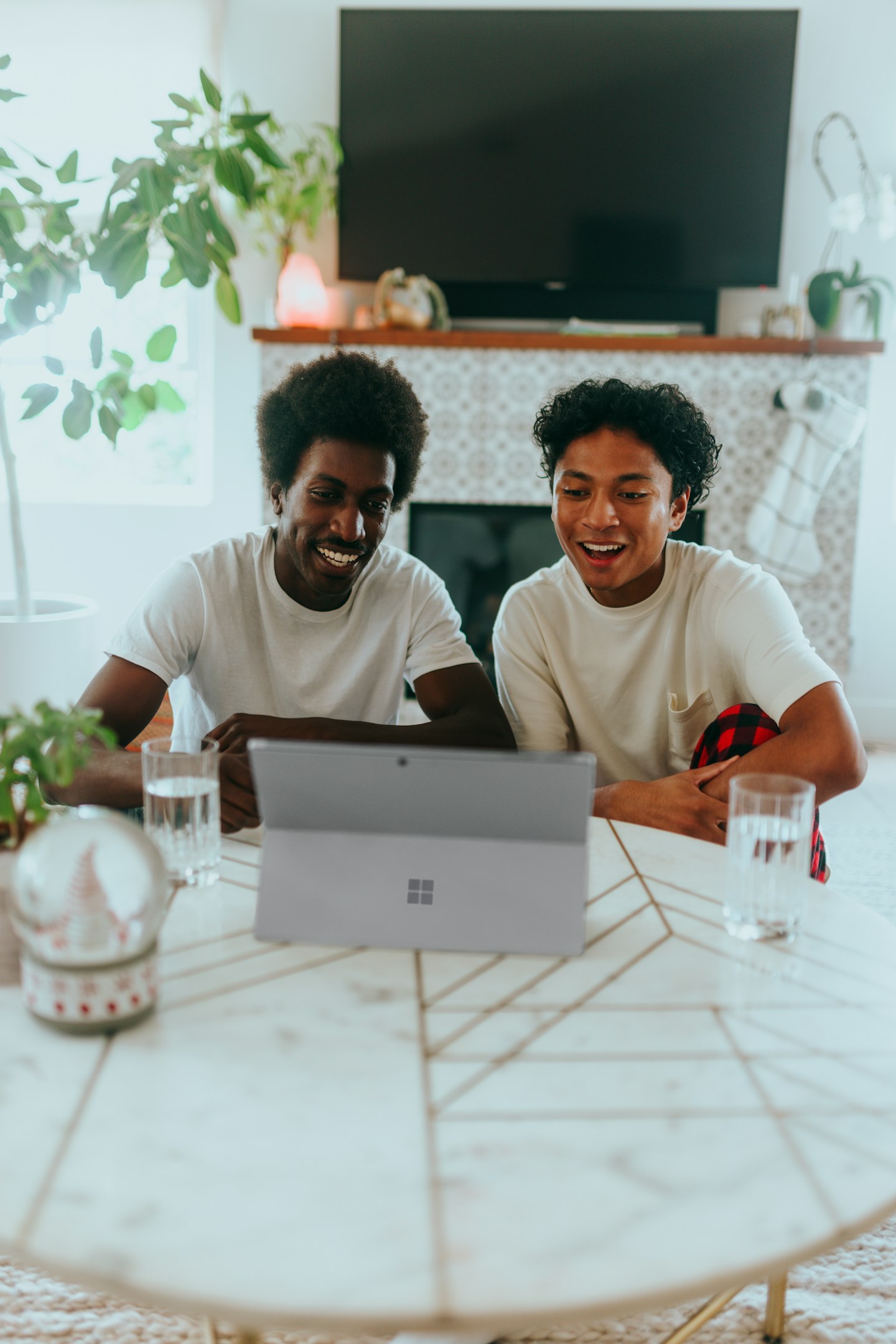 Two people smiling while looking at a laptop together