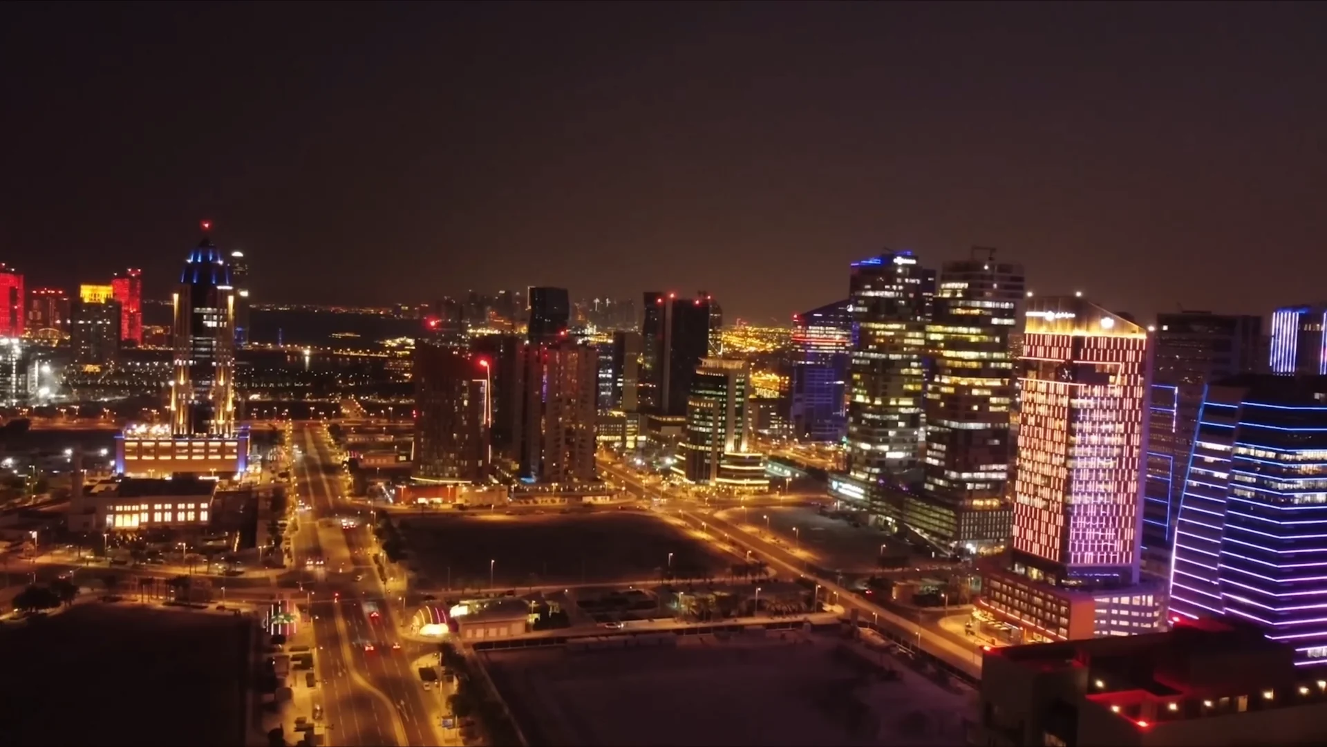 An aerial night view across Lusail’s illuminated towers, streets and waterfront