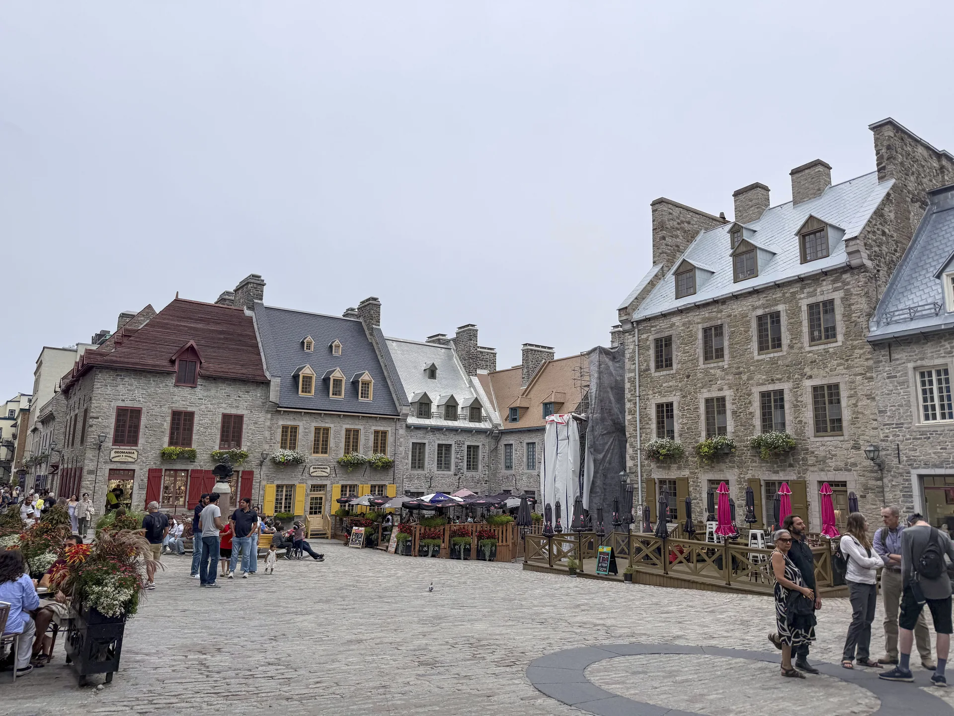 Stone façades, café terraces and pedestrians at Place Royale in Québec City.