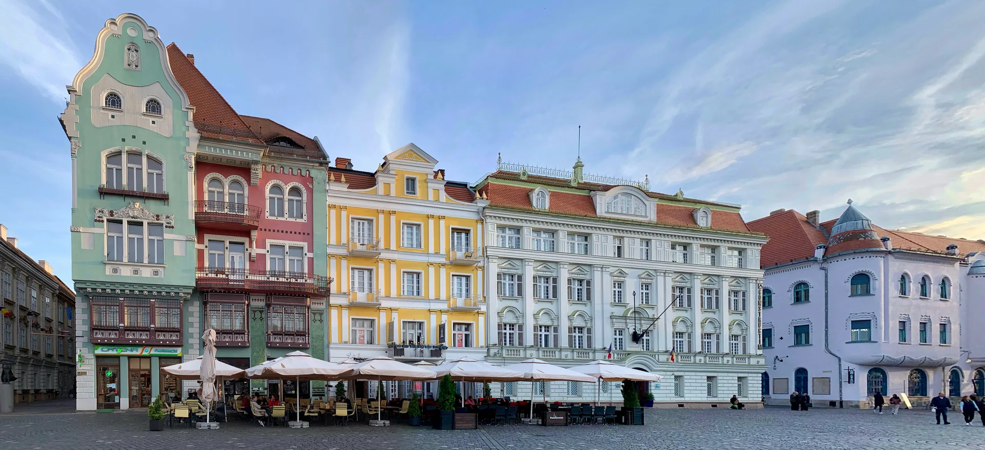 The colourful Brück House and neighbouring landmark façades on Piața Unirii in Timișoara.